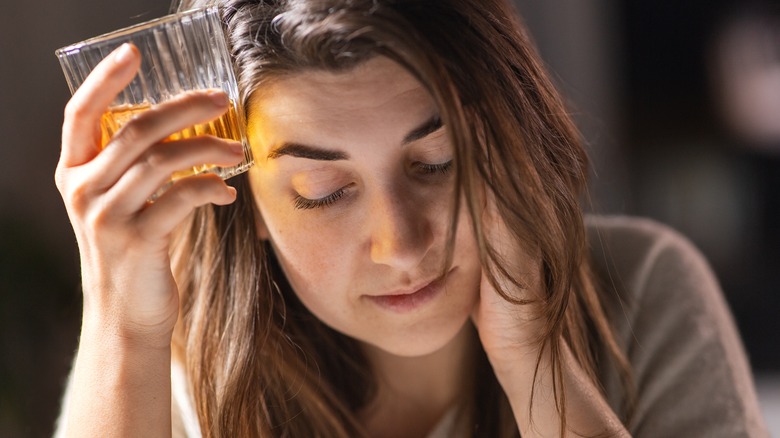 woman looking sad and drinking alcohol