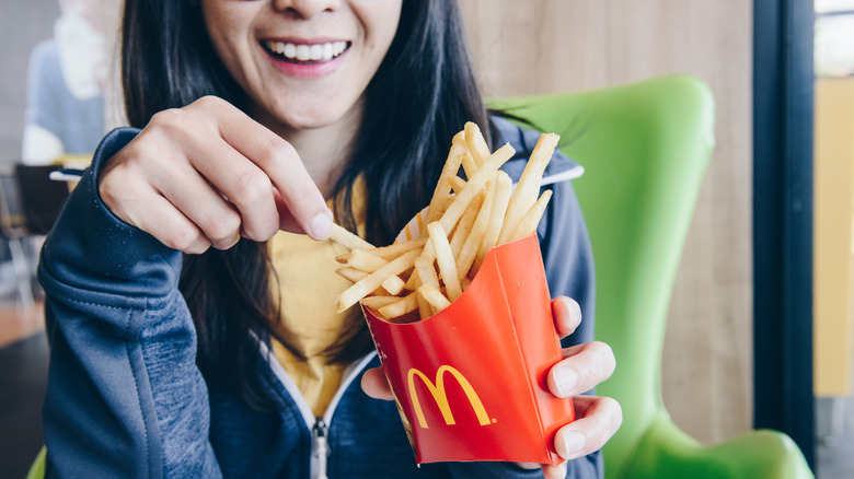 Woman eating McDonald's French fries