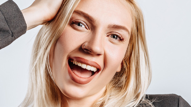 smiling woman with tooth gem