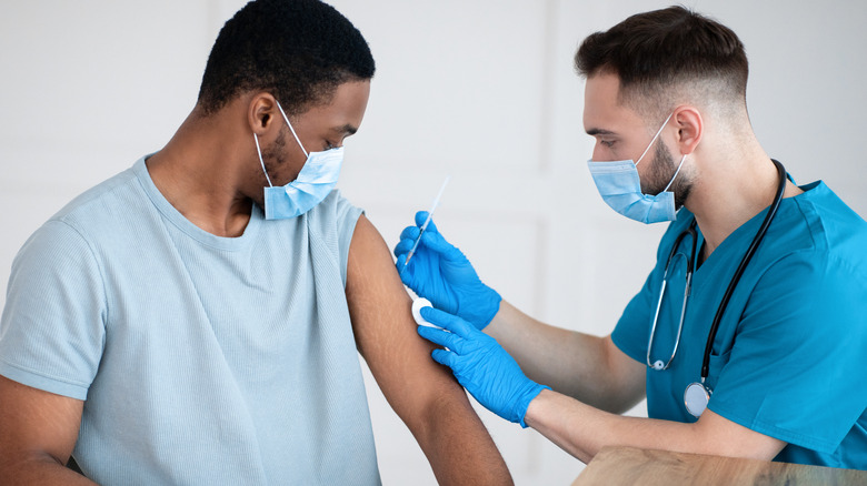 Doctor administering COVID-19 vaccine to patient