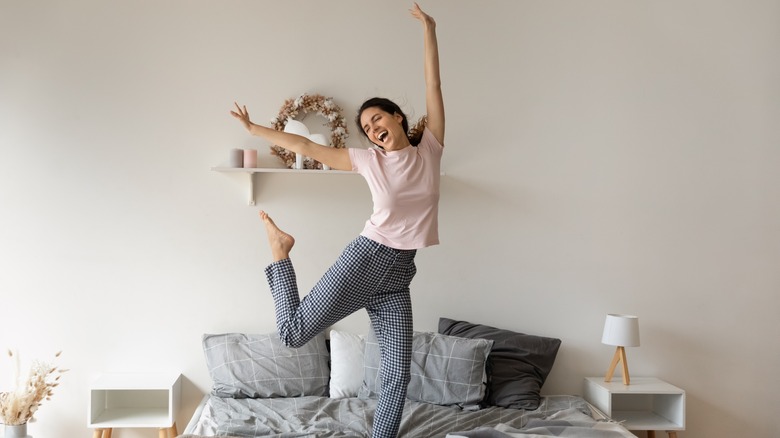 Lady in pajamas jumping on bed