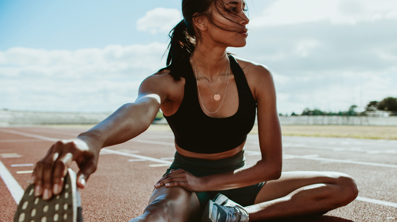 woman stretching on track
