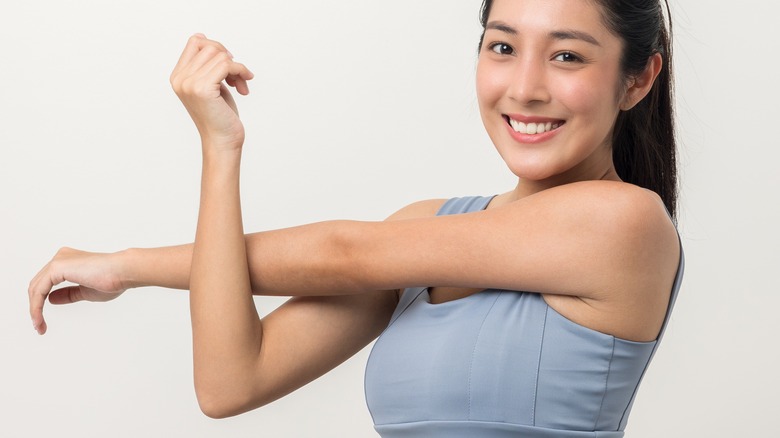 woman stretching arm as warmup