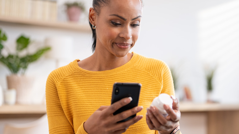 woman looking for discounts on her phone for her prescription