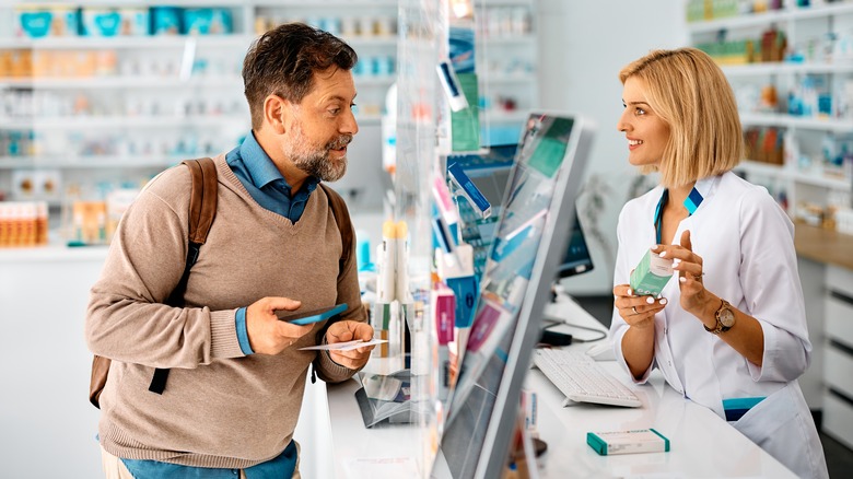 man asking a pharmacist a question