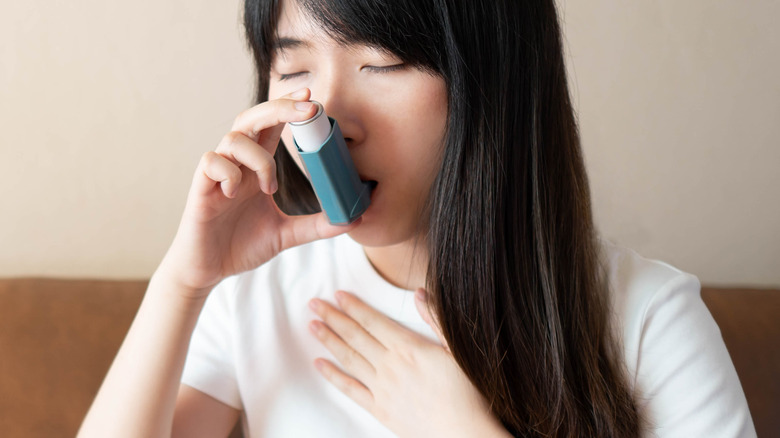 woman with asthma using inhaler