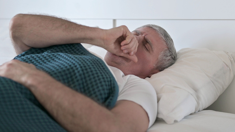 Man coughing in bed