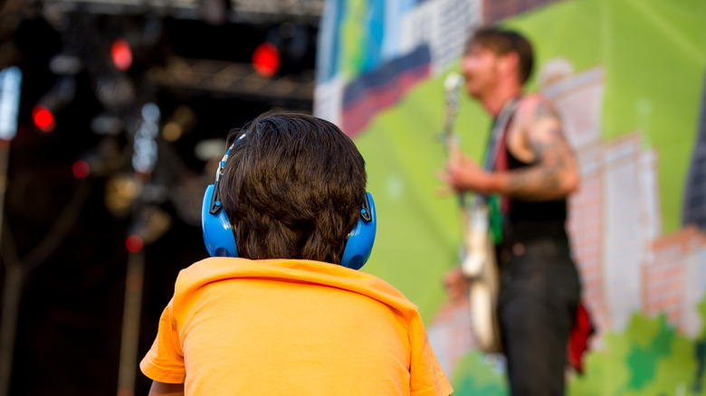 Kid wearing ear protection at a concert 