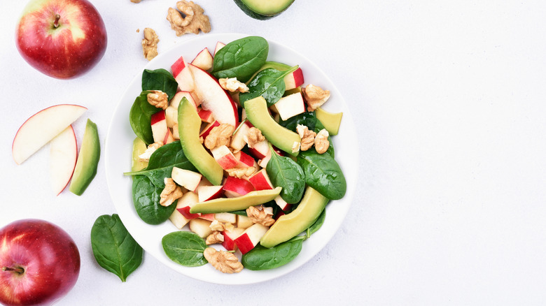 A salad with avocados and apples
