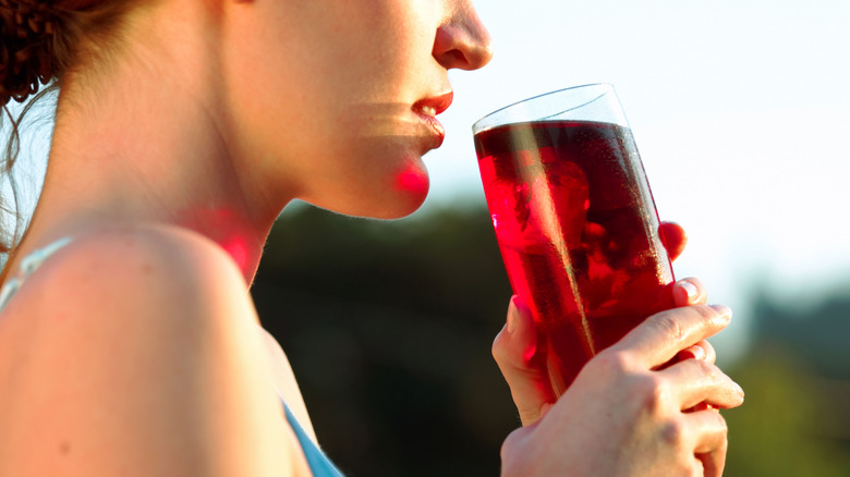 woman drinking glass of cranberry juice