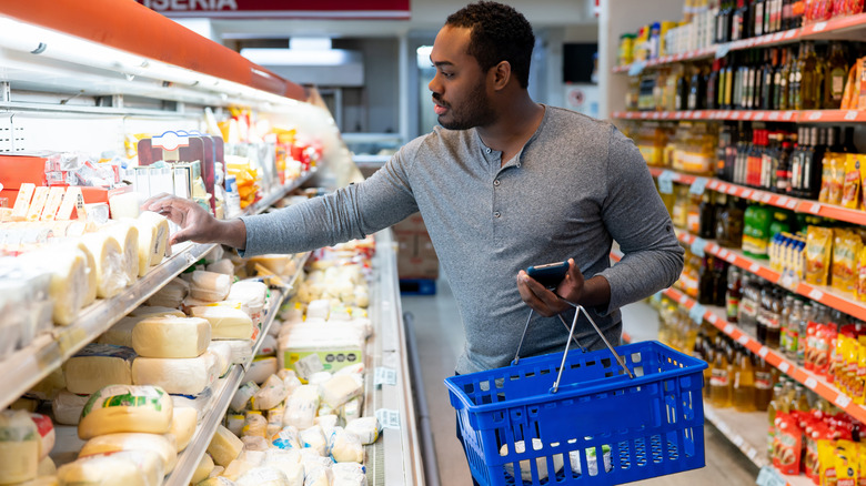 Man shopping for block of cheese
