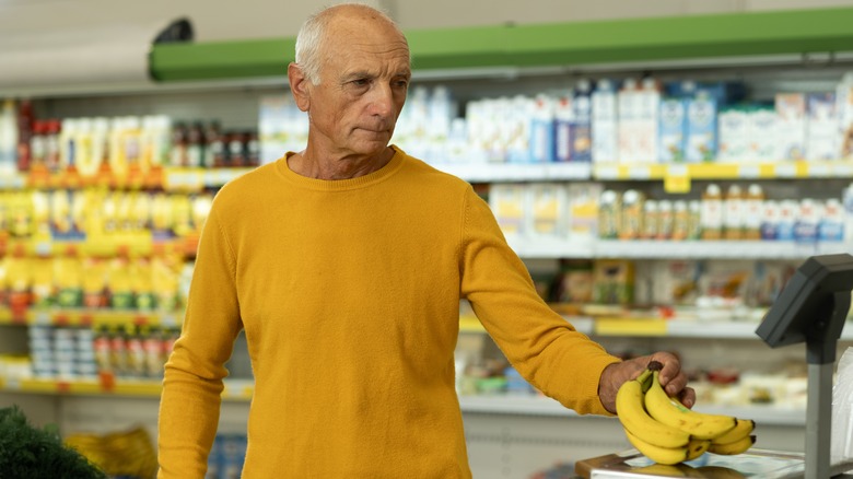 Man purchasing bananas at store