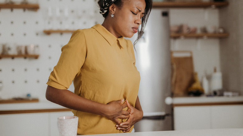 Woman touching stomach in pain