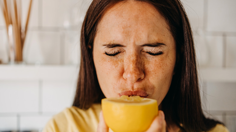 Woman sucking on lemon slice