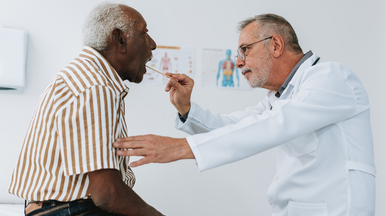 Doctor examining patient's mouth