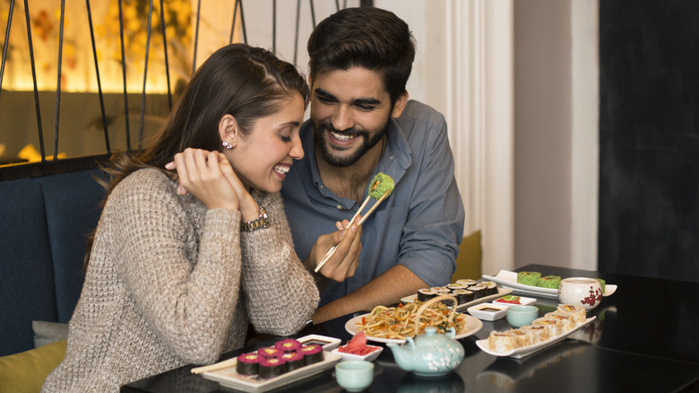 couple eating sushi in a restaurant