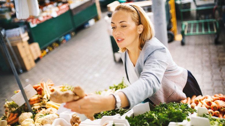 woman shopping for ginger in produce aisle