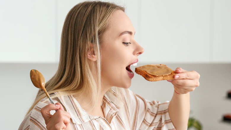 Spreading peanut butter on toast