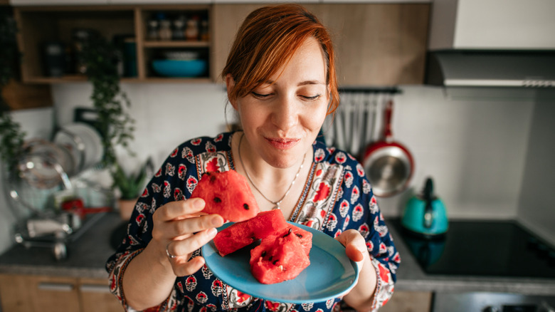 Smiling woman eating watermelon