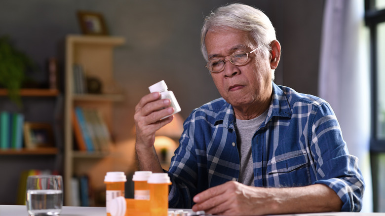 older man reading his medication labels
