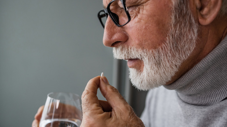 older man taking medication