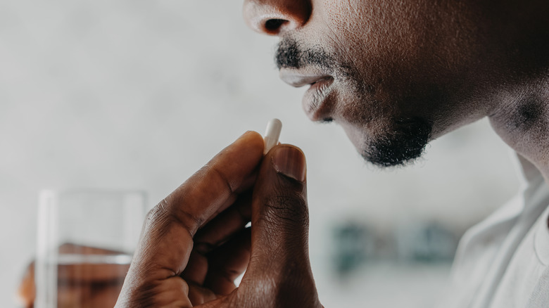 Man taking a pill with water