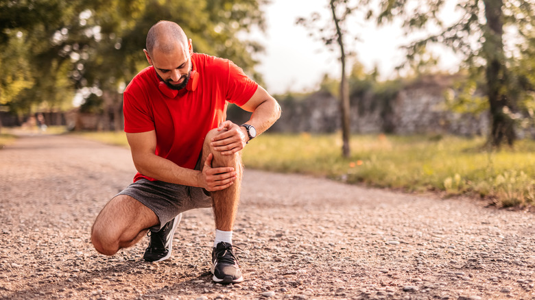 man holding his knee in pain
