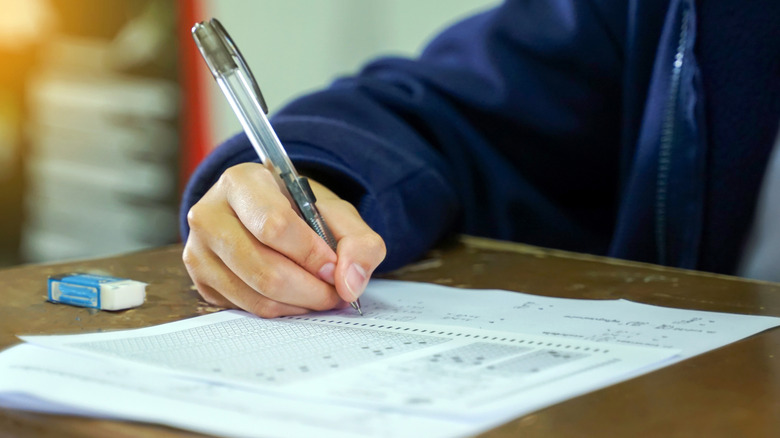 student writing on a piece of paper