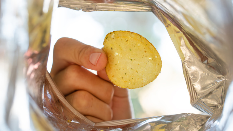 man's hand reaching for potato chip