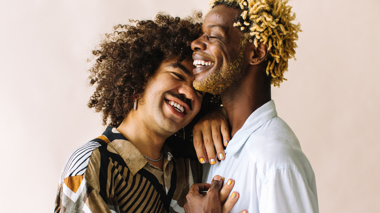 lgbtq couple embracing and smiling