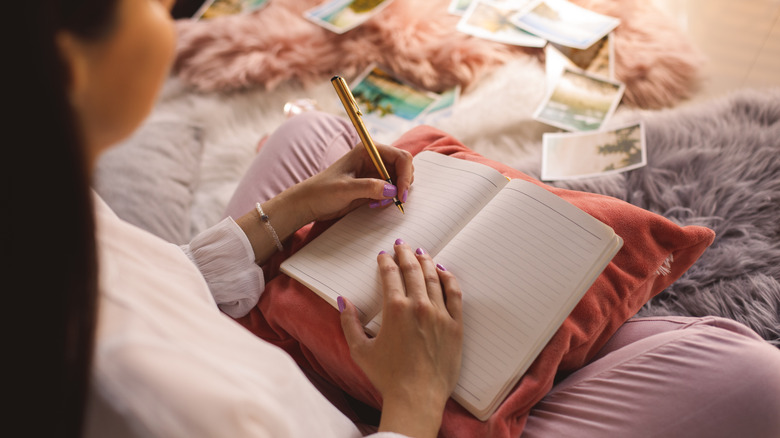 Left-handed person writing in journal