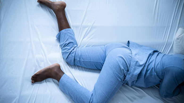 person with legs uncovered in bed
