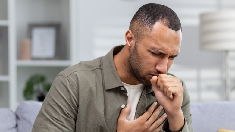 Coughing man holding chest