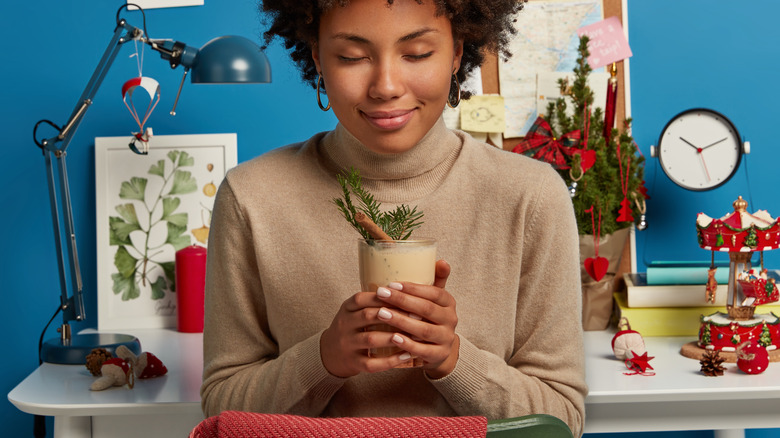 smiling woman holding eggnog cocktail