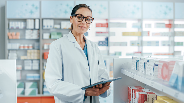 Pharmacist with glasses holding clipboard