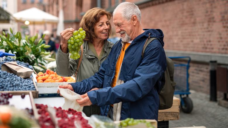 mature couple shopping for fresh produce at market