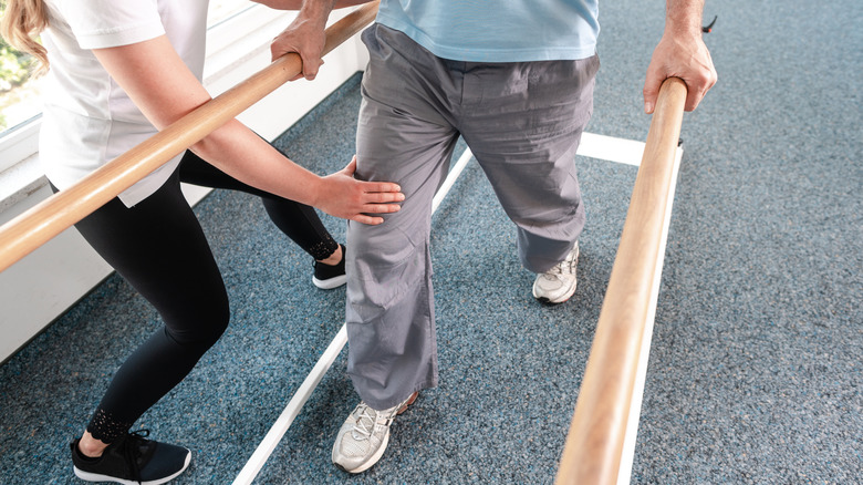physical therapist working with patient on walking