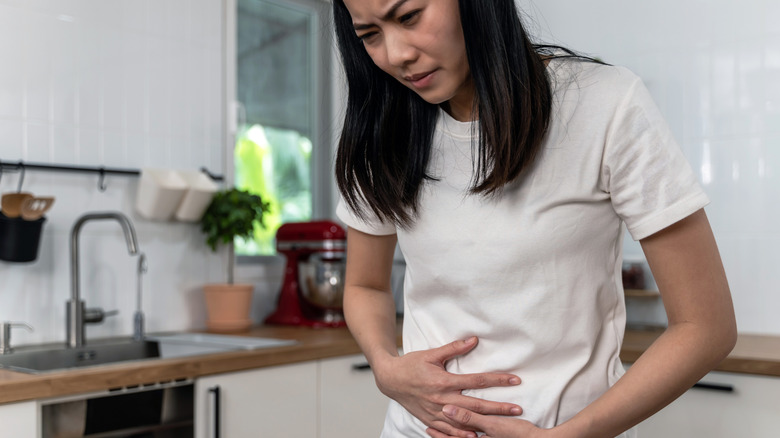 woman doubled over with pelvic area discomfort