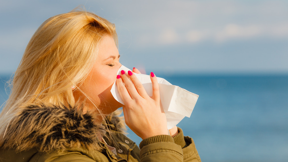 A woman sneezing from being exposed to light 