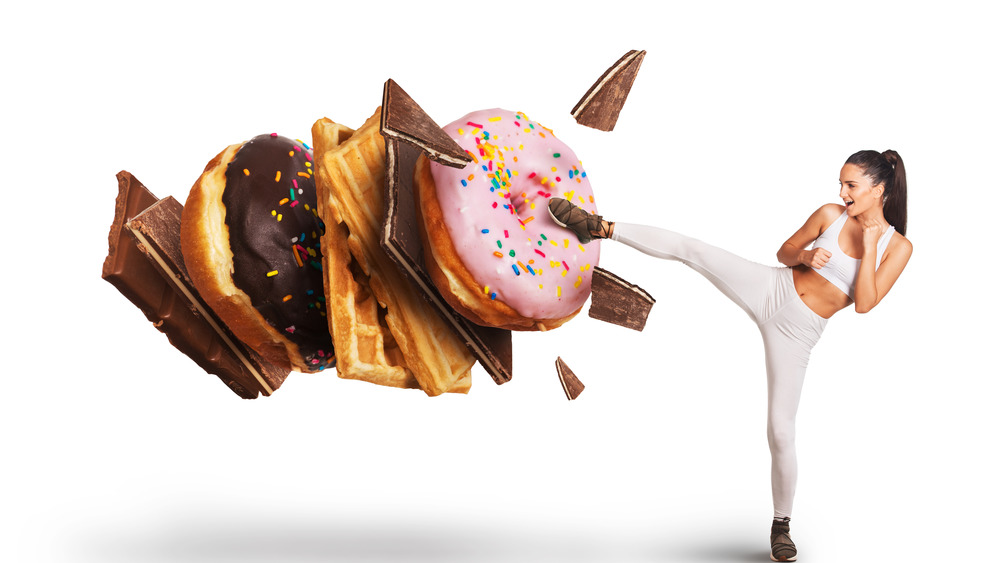 Woman kick-boxing donuts