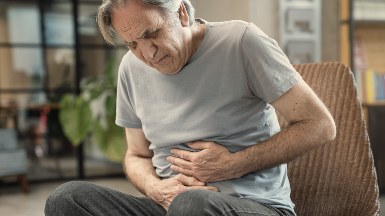 A senior man holding his stomach in pain