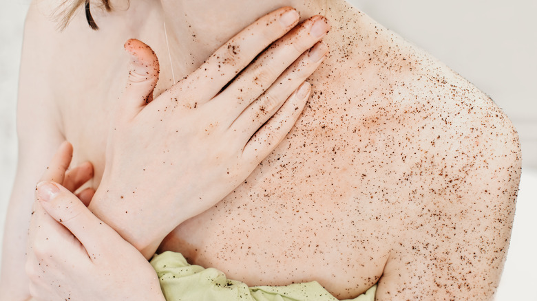 woman exfoliating skin in bathroom