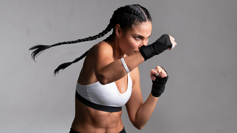 A woman boxing against a grey background