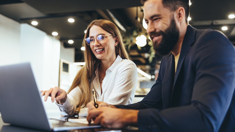 cheerful couple sitting at computers