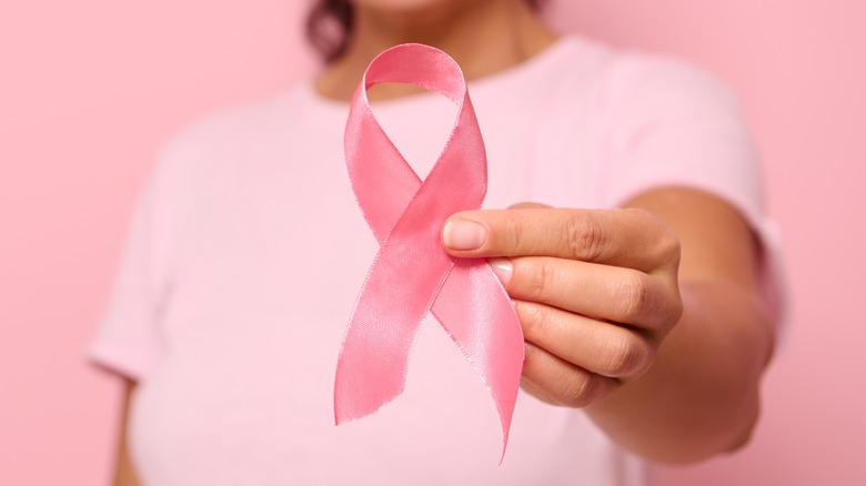 woman holding pink breast cancer ribbon