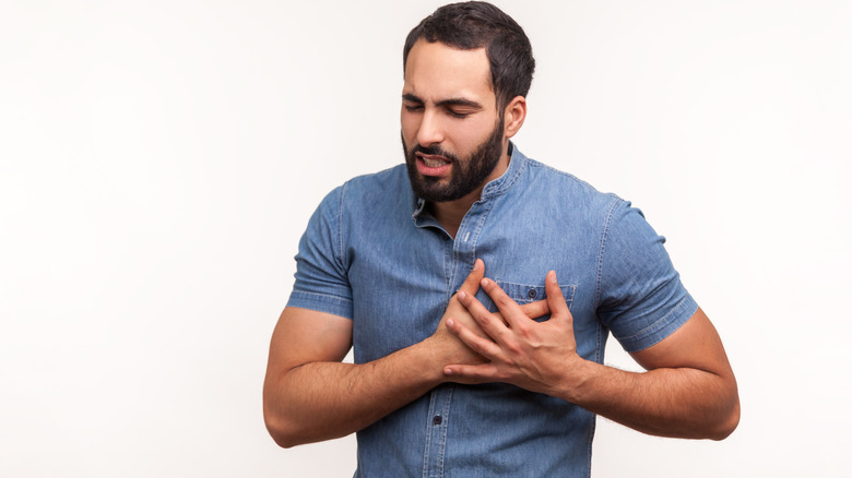 man holding his left breast