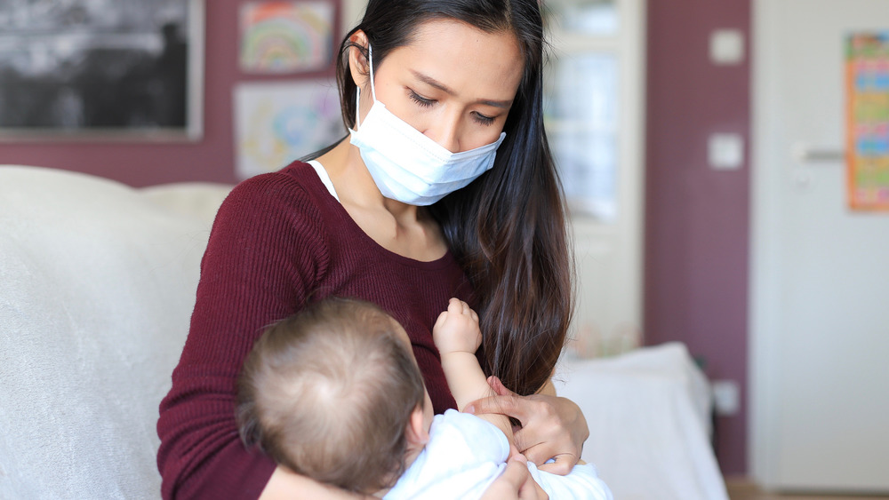 Woman's breastfeeding with mask
