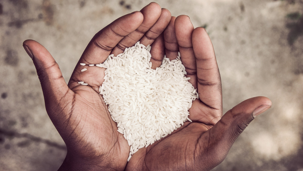 Hands holding rice in the shape of a heart