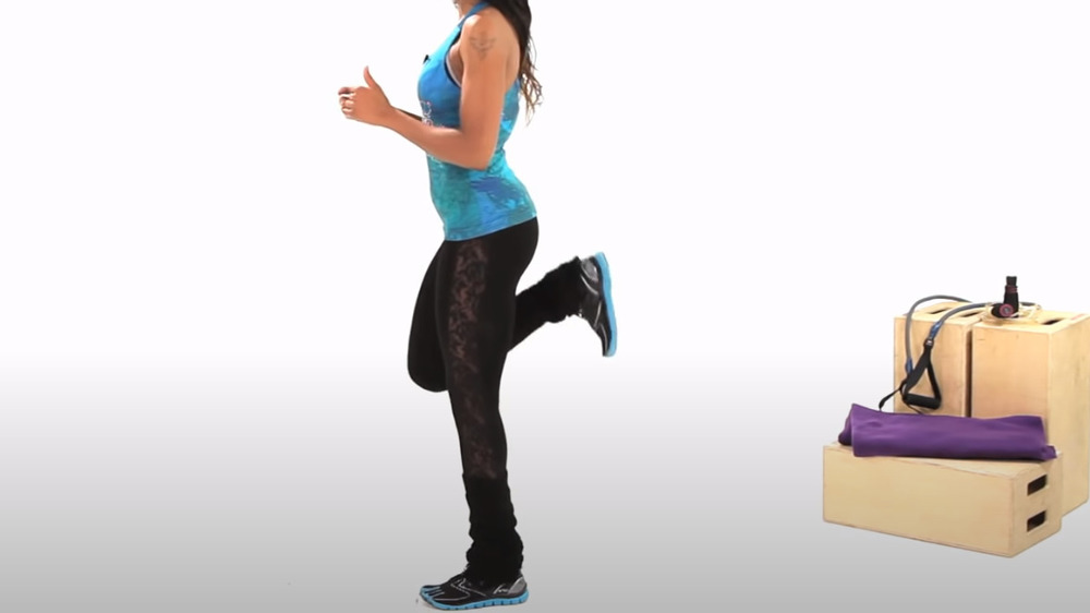 Woman demonstrating Butt kicks from the neck down 