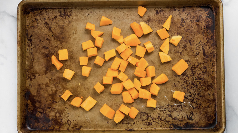 Raw butternut squash on a baking tray